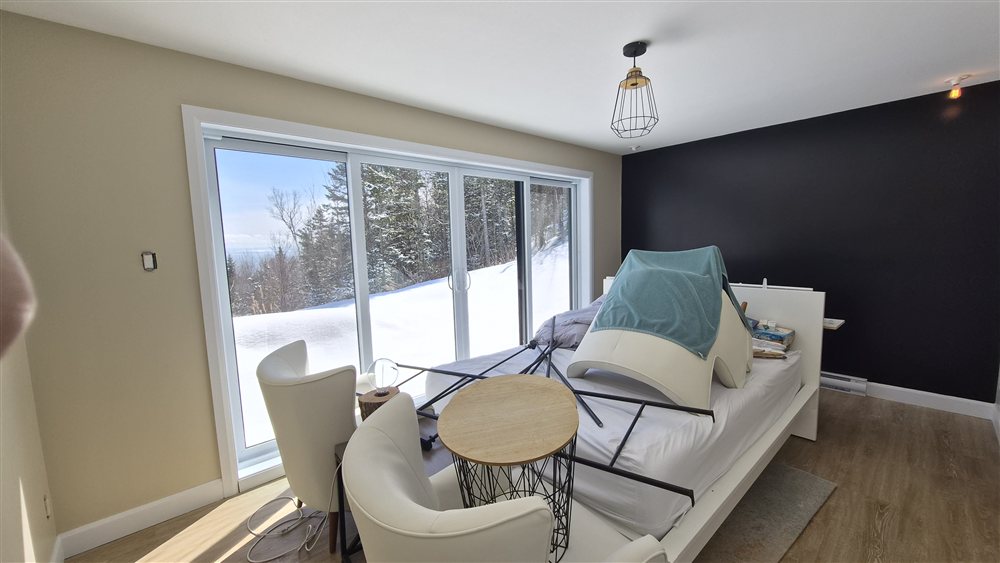 Chambre avec mur accent noir et vue sur le fleuve